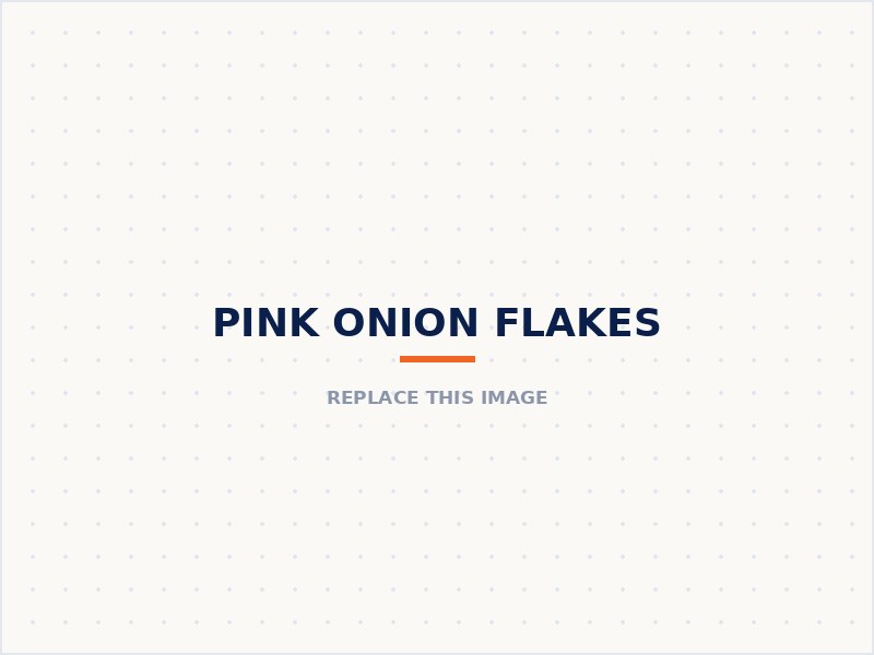 Pink onion flakes in a wooden bowl beside a whole pink onion